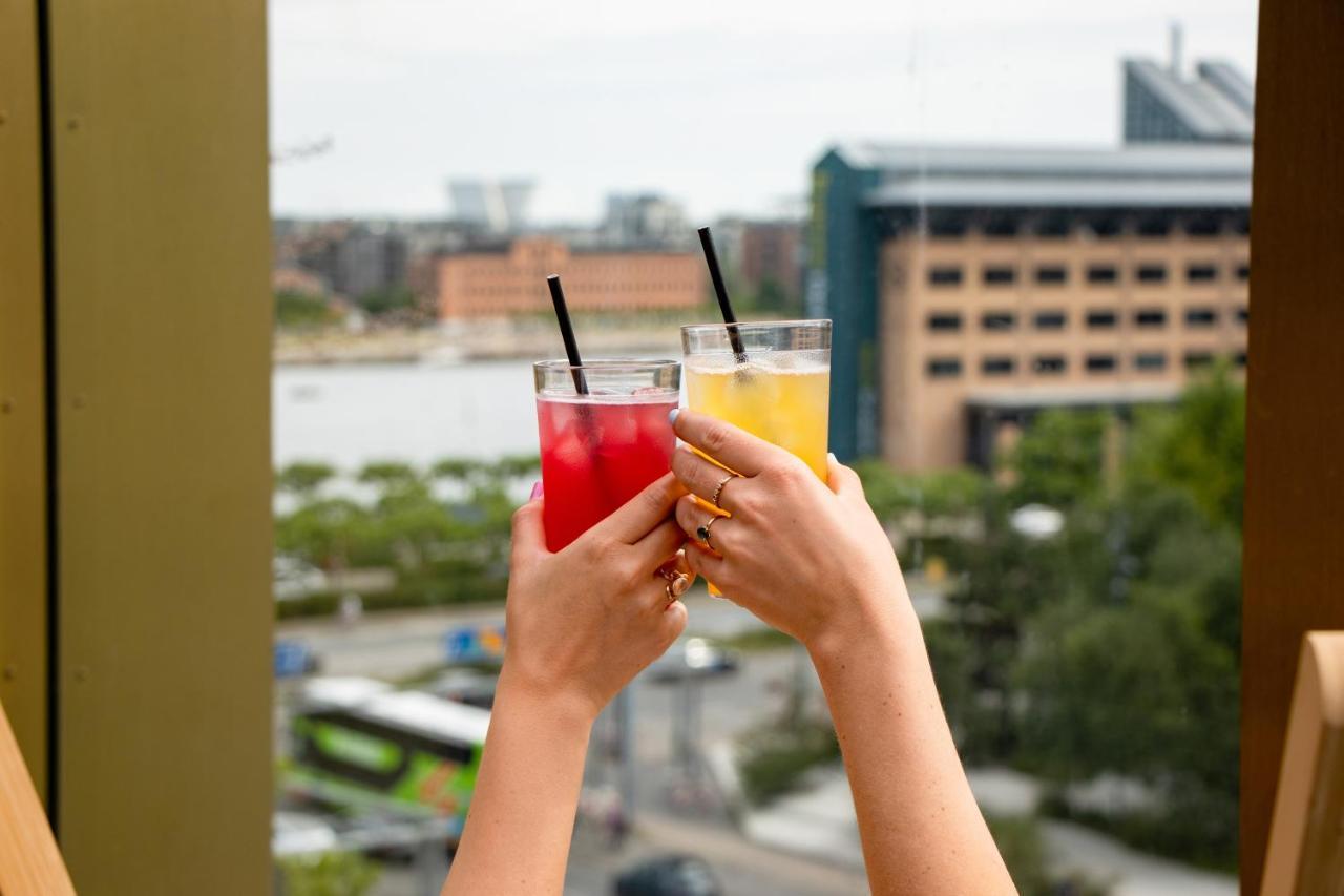 Next House Copenhagen旅舍 外观 照片 Two hands holding drinks and toasting with them.